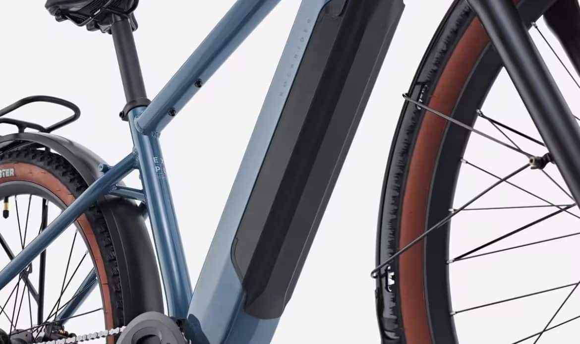 Roue arrière du VTC électrique Decathlon E-EXPL 100 LTD avec moteur intégré, transmission Microshift 8 vitesses, porte-bagages et garde-boue pour un usage polyvalent.