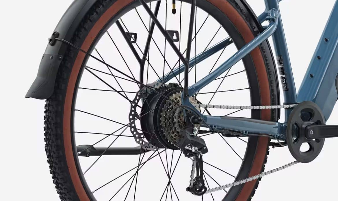 Roue arrière du VTC électrique Decathlon E-EXPL 100 LTD avec moteur intégré, transmission Microshift 8 vitesses, porte-bagages et garde-boue pour un usage polyvalent.