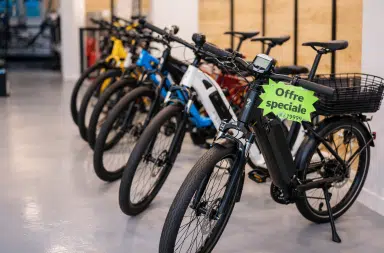 Vélos électriques exposés en magasin avec une étiquette “offre spéciale”, illustrant la baisse des prix en Europe.