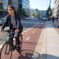 Cycliste utilisant une piste cyclable en ville aux côtés des piétons, illustrant les déplacements urbains facilités par la navigation mains libres et l’intelligence artificielle de Google Maps.