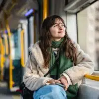 Jeune femme regardant par la fenêtre d'un bus électrique