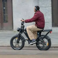 Homme roulant sur un fatbike électrique en ville, illustrant l’usage urbain quotidien de ce vélo à pneus larges.
