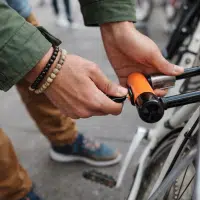 Personne attachant un vélo urbain avec un antivol en U pour prévenir le vol en ville