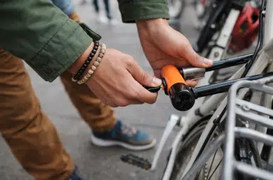 Personne attachant un vélo urbain avec un antivol en U pour prévenir le vol en ville