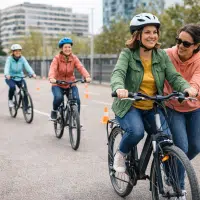 Femmes adultes apprenant à faire du vélo avec accompagnement dans une vélo-école en ville