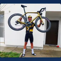 Cycliste soulevant son vélo doré retrouvé après un vol