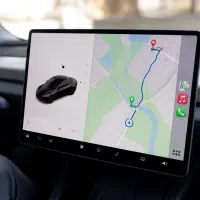 Interface Apple CarPlay sur écran central Tesla, affichant navigation et itinéraire de recharge