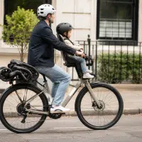 Poussette Faar Ride clipsée sur le porte-bagages d'un vélo en mode siège enfant