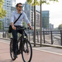 Cycliste en tenue de ville roulant à allure modérée pour aller travailler